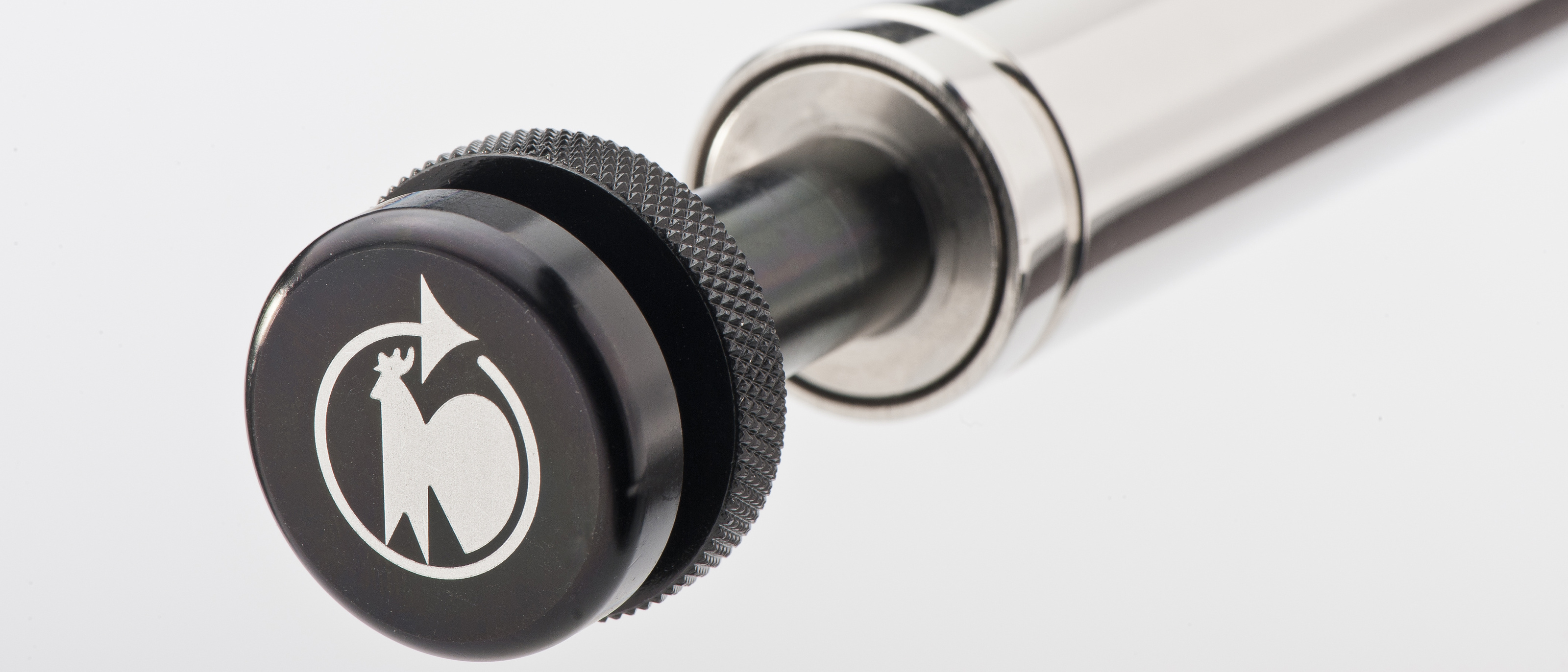 Detailansicht einer Gasfeder mit integriertem Auslösesystem von Hahn Gasfedern, ausgestattet mit einem ergonomischen Druckknopf für präzise Steuerung.
