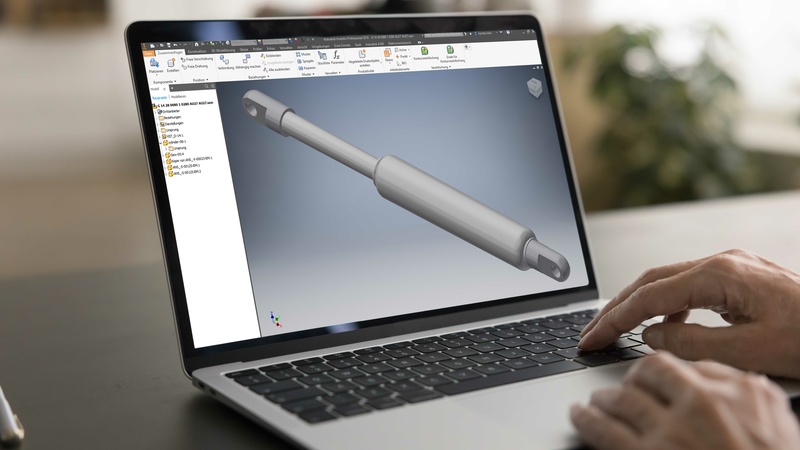 3D-Modell einer Gasfeder auf einem Laptop-Bildschirm, entwickelt mit CAD-Software für präzise Konstruktion und technische Planung.