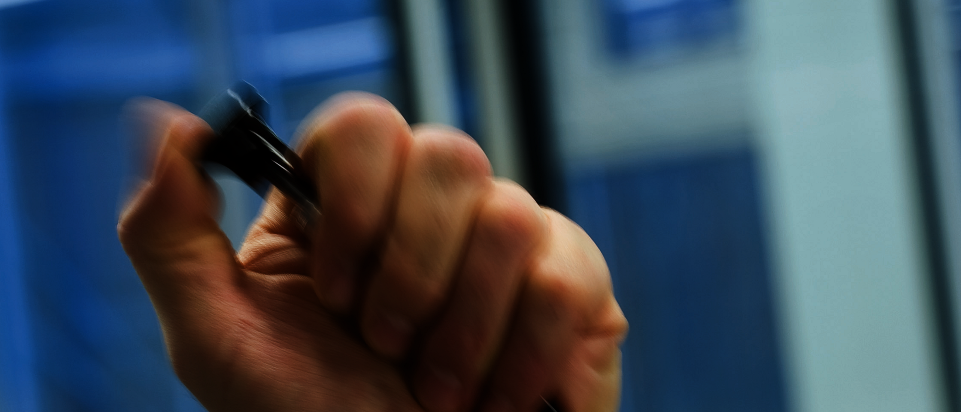 Hand hält ein Auslösesystem mit Bowdenzug zur präzisen Steuerung einer Gasfeder, ideal für ergonomische und sichere Anwendungen.