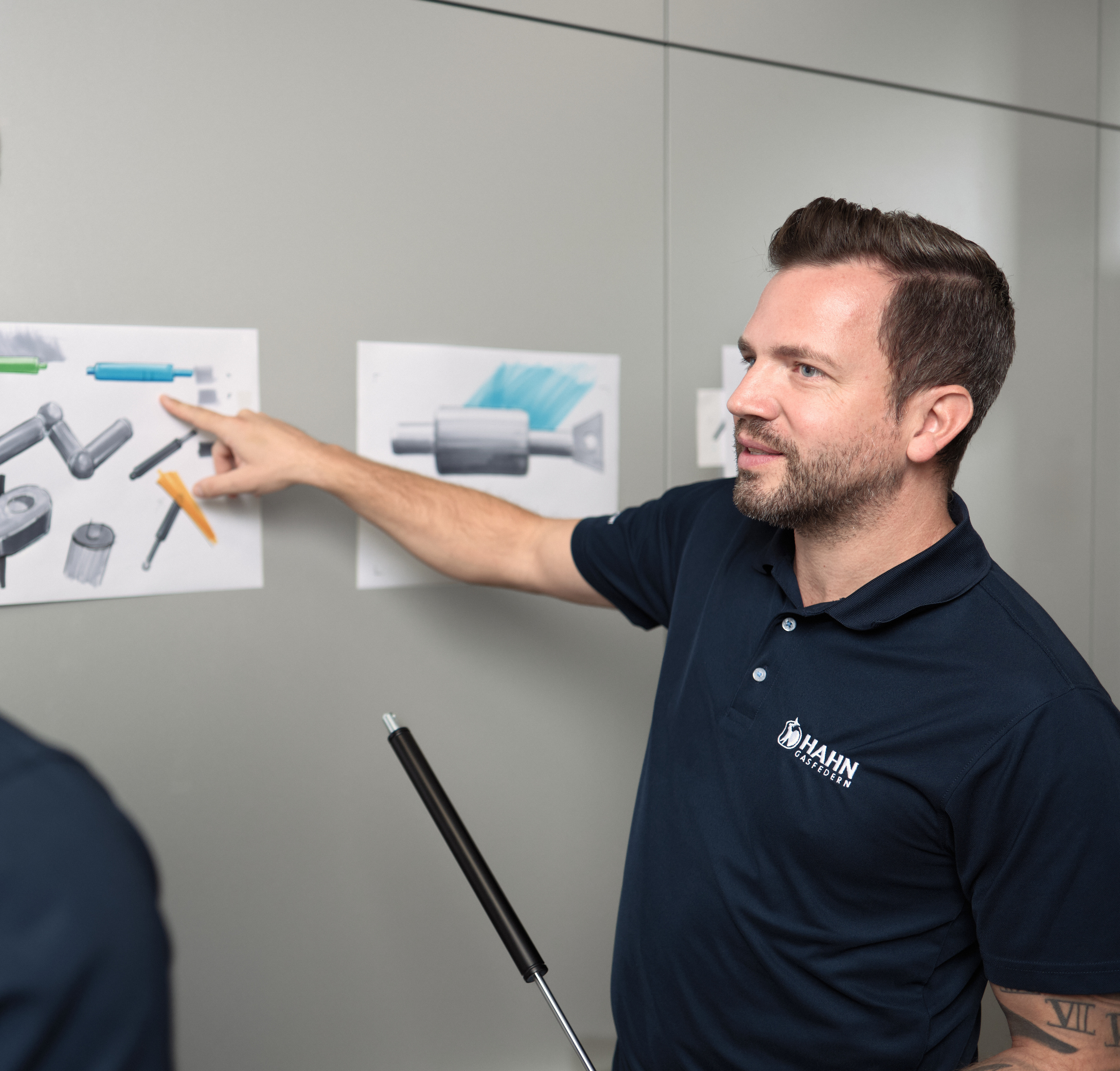 Mitarbeiter:innen von Hahn Gasfedern besprechen Zeichnungen – Innovation und Teamarbeit.