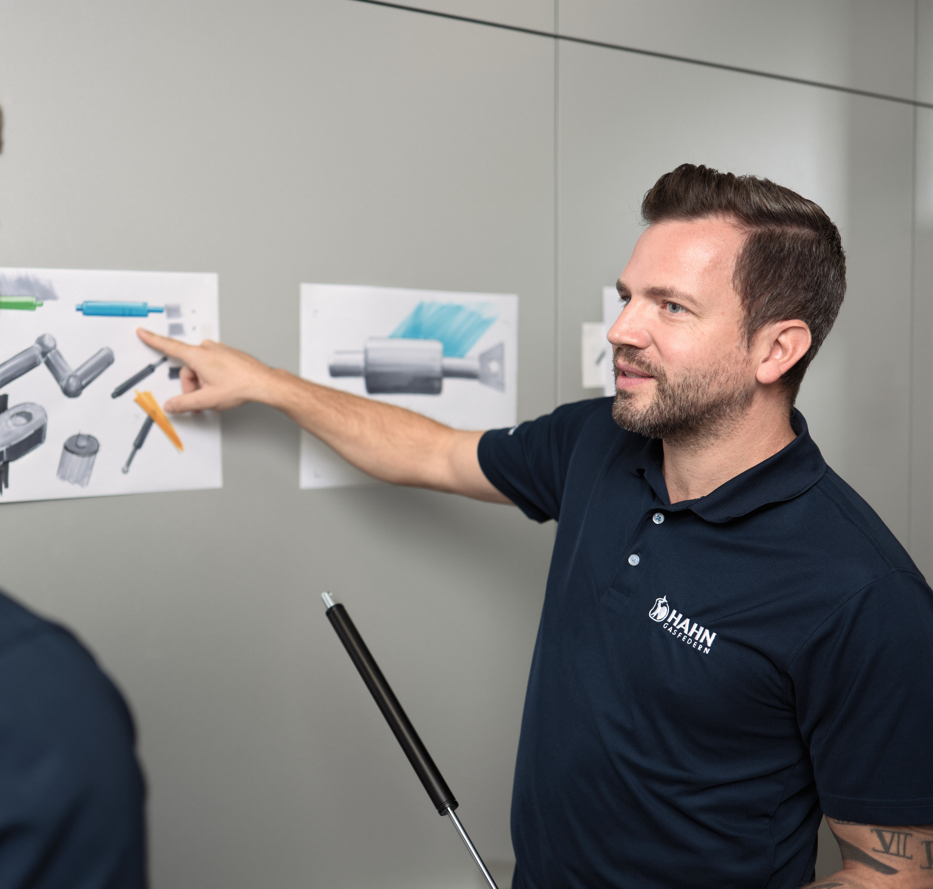 Mitarbeiter:innen von Hahn Gasfedern besprechen Zeichnungen – Innovation und Teamarbeit.