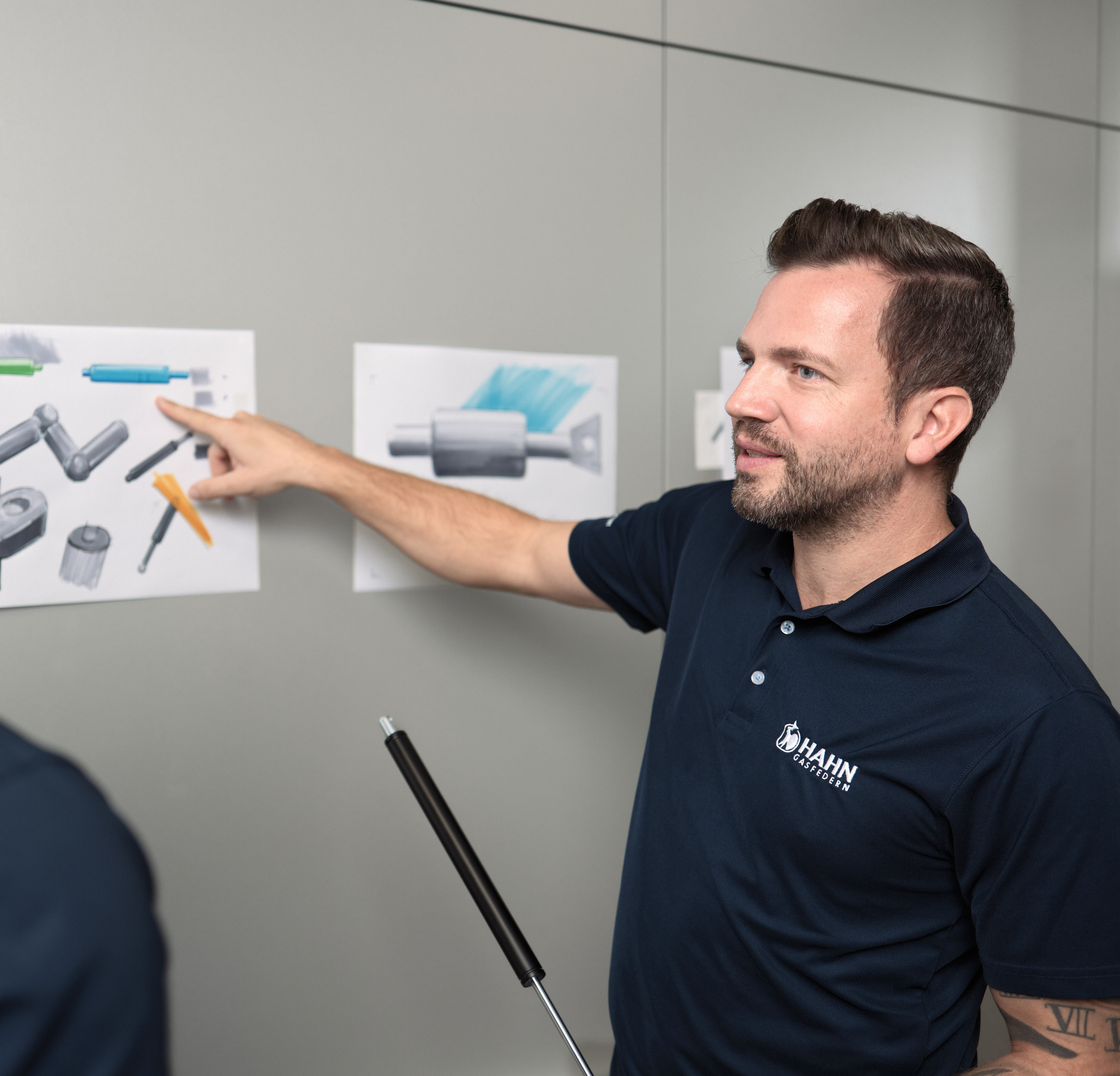 Mitarbeiter:innen von Hahn Gasfedern besprechen Zeichnungen – Innovation und Teamarbeit.