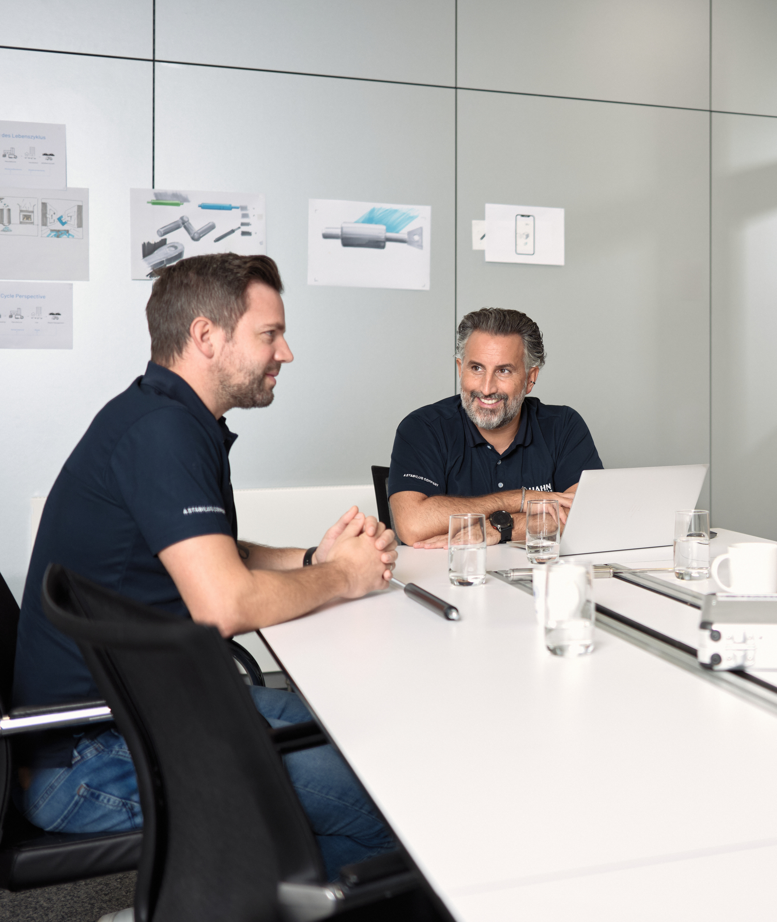 Teammeeting bei Hahn Gasfedern: Mitarbeitende besprechen Zeichnungen und Projekte.